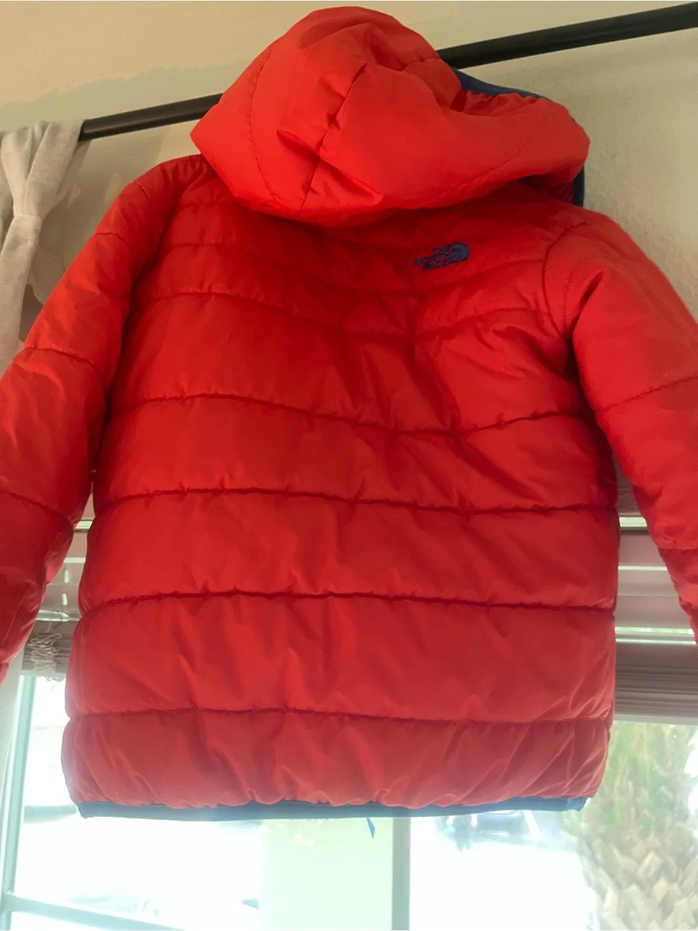 The North Face reversible Solid Red or Vibrant Striped side Puffer Jacket.